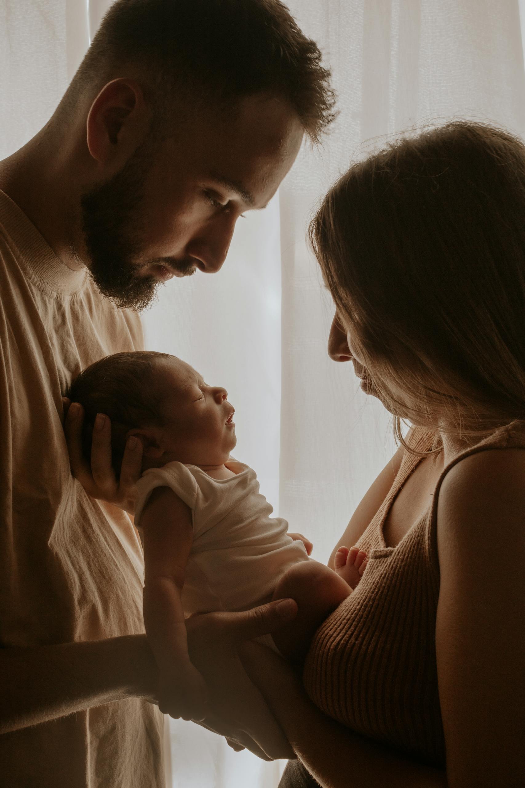 Loving parents holding their newborn, creating a serene and warm moment.